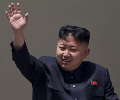 orth Korean leader Kim Jong Un waves from a balcony at the end of a mass military parade in Pyongyang's Kim Il Sung Square.  AP