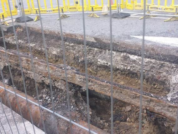 Rusting tram tracks are visible during excavation work