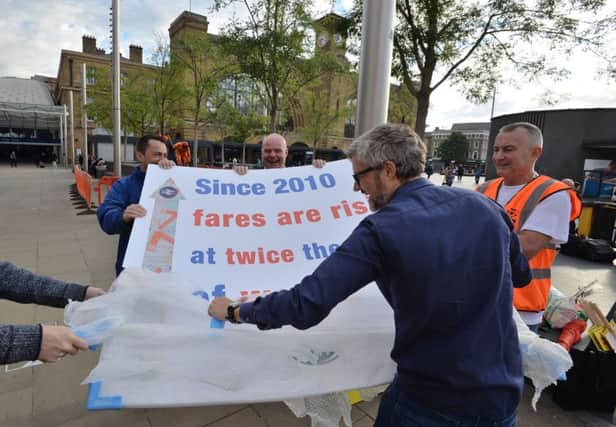 Rail unions and campaigners unveil a banner during a protest against rail fare increases