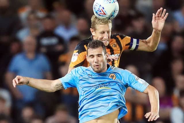 In command:  Leo Bonatini loses this aerial challenge to Hull City's Michael Dawson.