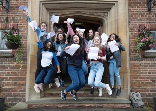 A-Level students jump for joy after receiving their results.