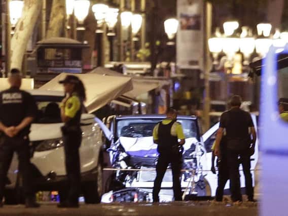 Police officers stand next to the van involved on an attack in Las Ramblas, Barcelona. Picture: AP