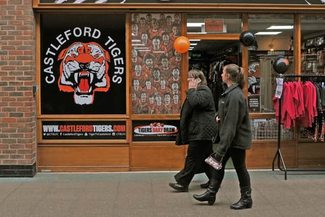 A couple walk past Castleford Tigersb shop in the Carlton Lanes shopping centre. Castleford clinched the rugby league title for the first time in their history. Picture Tony Johnson.