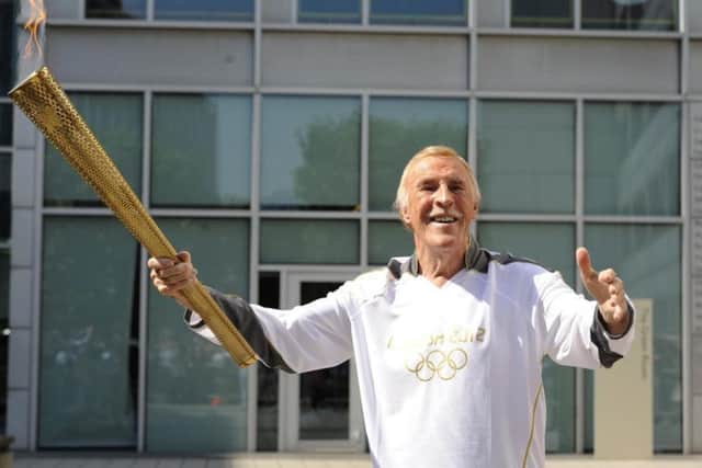 Sir Bruce Forsyth carries the Olympic Flame on the Torch Relay leg through Kensington and Chelsea