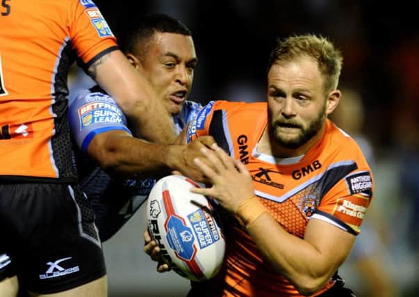 Castleford's Paul McShane is tackled by Wakefield's Reece Lyne.