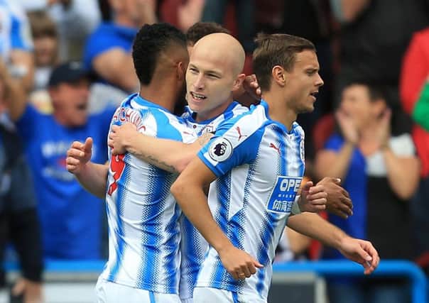 Huddersfield Town's Aaron Mooy (centre) celebrates with his team-mates after scoring his side's first goal during the Premier League match