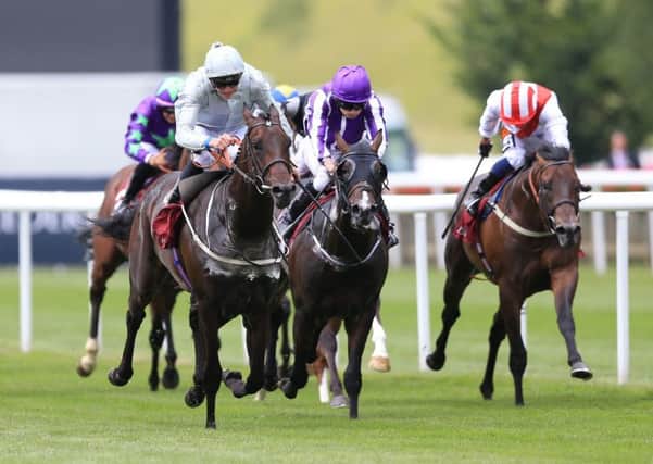 Cardsharp (left) ridden by Jamie Doyle wins The Arqana July Stakes during Ladies Day of The Moet and Chandon July Festival at Newmarket. Picture: Nigel French/PA