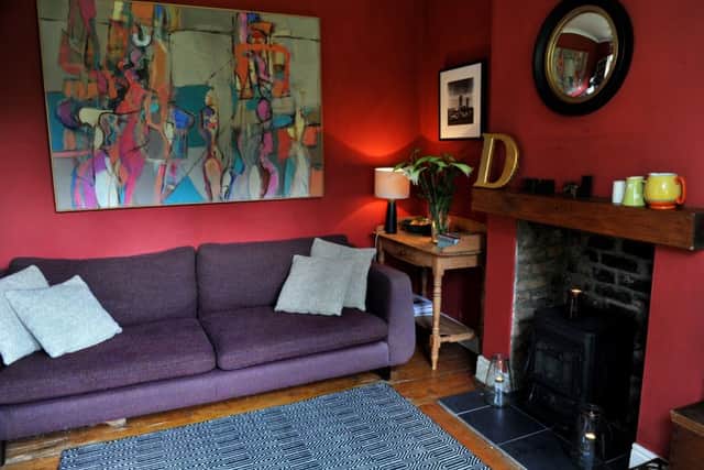 The snug with red walls and painting by John Creighton