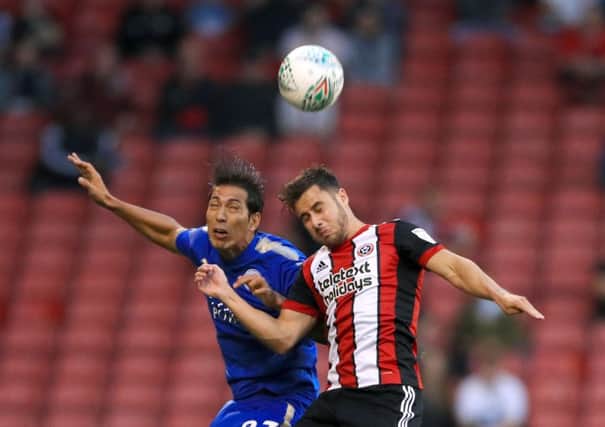 Sheffield United's George Baldock battles for the ball with Leicester City's Leonardo Ulloa at Bramall Lane on Tuesday night. Picture: Tim Goode/PA.