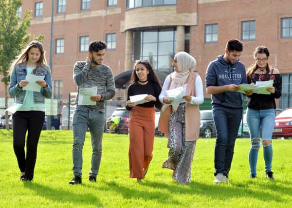 Hanaa Khan with fellow pupils opening their results at Dixons Trinity Academy in Bradford. Picture Bruce Rollinson