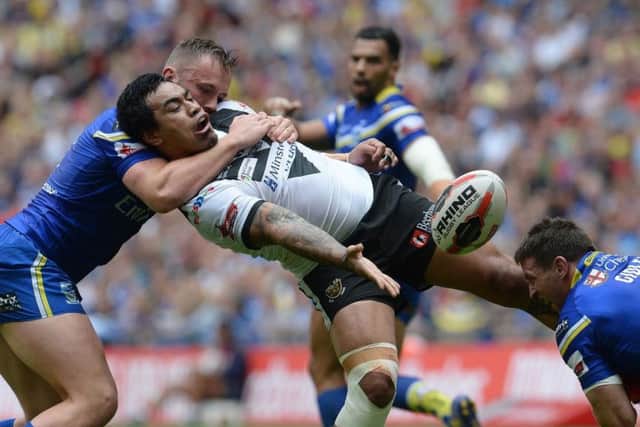Mahe Fonua passes the ball under pressure from Warrington Wolves' Ben Currie and Kurt Gidley in last year's Wembley final. Picture: PA.