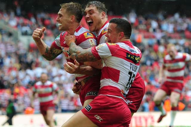 Wigan's Sam Tomkins celebrates with Gil Dudson and Chris Tuson after scoring a try during the Challenge Cup Final at Wembley against Hull FC in 2013. Picture: Anna Gowthorpe/PA