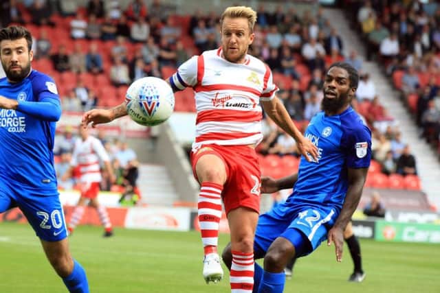 Doncaster Rovers' James Coppinger battles for the ball against PEterborough. Picture: Chris Etchells