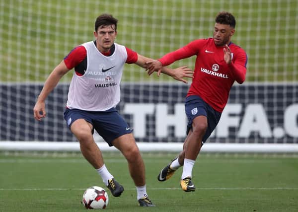 Hands off: England's Harry Maguire and Alex Oxlade-Chamberlain during a training session at St Georges' Park.