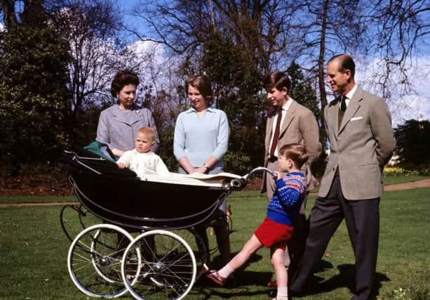 Prince Andrew rocking Prince Edward in 1965, watched by the Queen , Princess Anne, the Prince of Wales and the Duke of Edinburgh