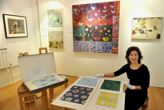 May Catt, curator at The Mercer Gallery,  with some of the designs by Sheila Bownas.