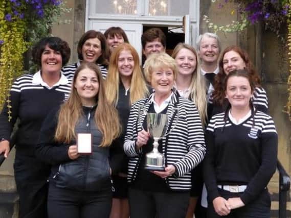Huddersfield ladies' captain Vicki Wimpenny holds the trophy after the club's fourth successive victory in the Yorkshire Ladies County Golf Association's Scratch League.