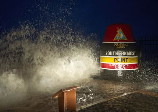 Waves crash against the Southernmost Point in Key West