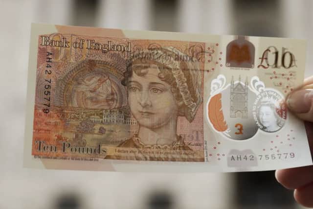 One of the new British 10 pound notes is posed for photographs outside the Bank of England in the City.
