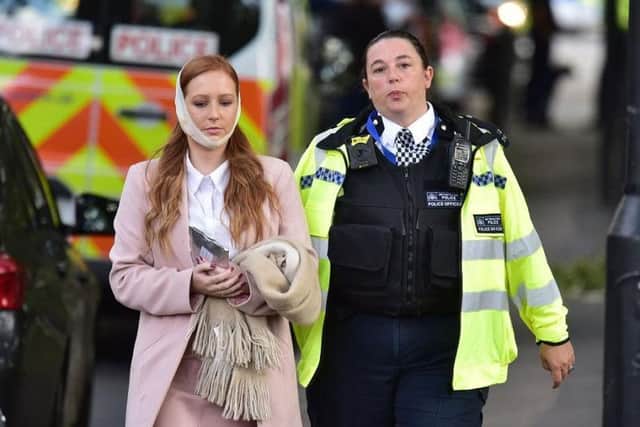 An injured woman is assisted by a police officer close to Parsons Green station in west London after Scotland Yard declared a terrorist incident following a blast sent a "fireball" and a "wall of flame" through a packed London Underground train. Picture: Stefan Rousseau/PA Wire