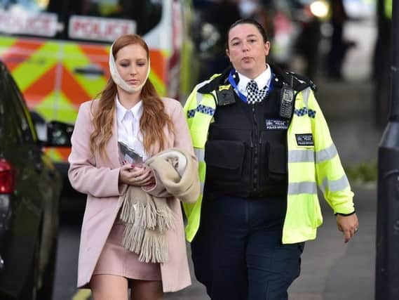 An injured woman is assisted by a police officer close to Parsons Green station in west London after Scotland Yard declared a terrorist incident following a blast sent a "fireball" and a "wall of flame" through a packed London Underground train. Picture: Stefan Rousseau/PA Wire