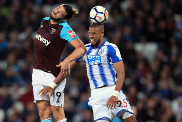 West Ham United's Andy Carroll (left) and Huddersfield Town's Mathias Jorgensen battle for the ball
