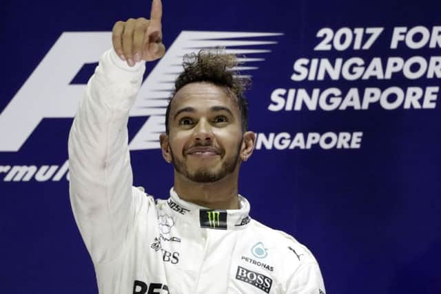 Mercedes driver Lewis Hamilton of Britain celebrates after winning the Singapore Formula One Grand Prix on the Marina Bay City Circuit Singapore, Sunday, Sept. 17, 2017. (AP Photo/Wong Maye-E)