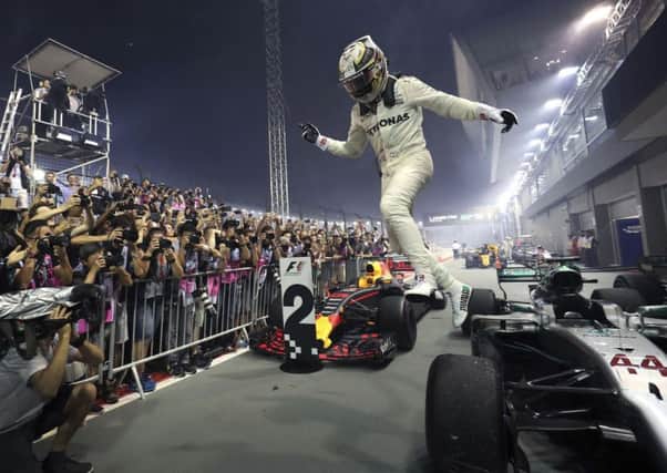 Mercedes driver Lewis Hamilton leaps from his car after winning the Singapore Grand Prix. Picture: AP/Yong Teck Lim