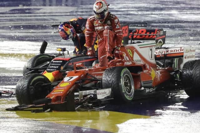 WALKING HOME: Ferrari driver Kimi Raikkonen, right, and Red Bull's Max Verstappen leave their cars after colliding at the start of the Singapore Grand Prix. Picture: AP/Wong Maye-E