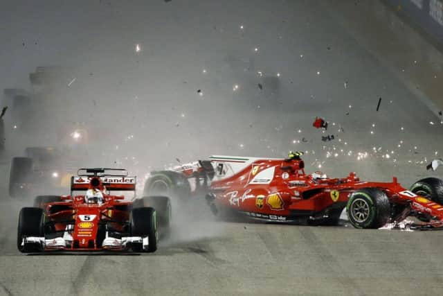 CRASHING OUT: Ferrari driver Kimi Raikkonen, right, collides with team-mate Sebastian Vettel at the start of the Singapore Grand Prix. Picture: AP/Yong Teck Lim
