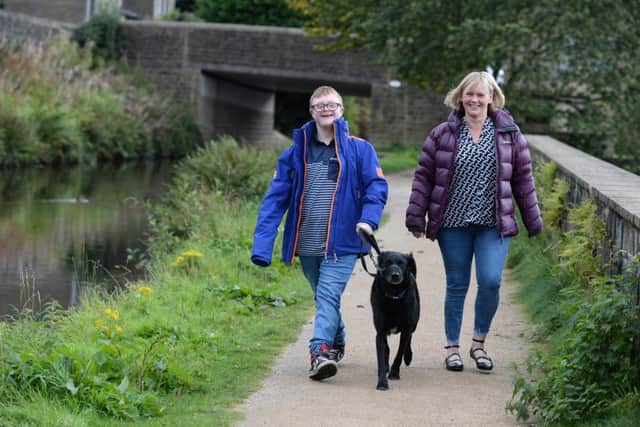 Jack Mawer, 14, walks his dog along the canal in Mytholmroyd with mother Mandy.  Picture Bruce Rollinson