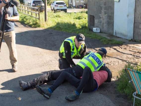 A demonstrator is restrained by police in Kirby Misperton on Tuesday.