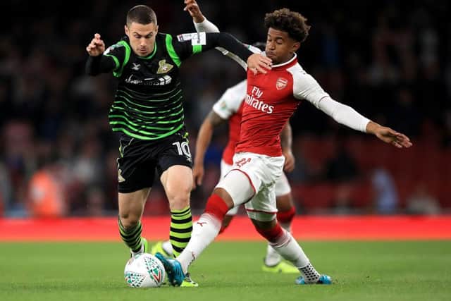 Doncaster Rovers' Tommy Rowe (left) and Arsenal's Reiss Nelson (right) battle for the ball during the Carabao Cup, Third Round match at the Emirates Stadium