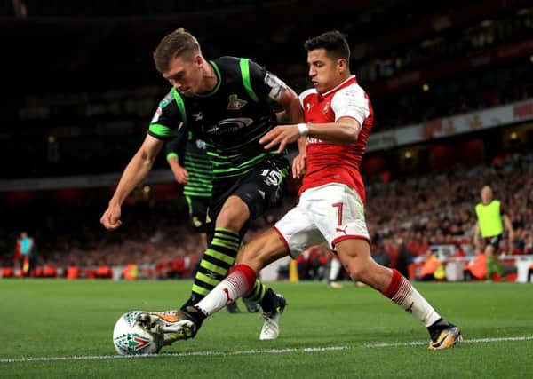 Arsenal's Alexis Sanchez (right) and Doncaster Rovers' Joe Wright during the Carabao Cup, Third Round match at the Emirates Stadium, London. (Picture: PA)