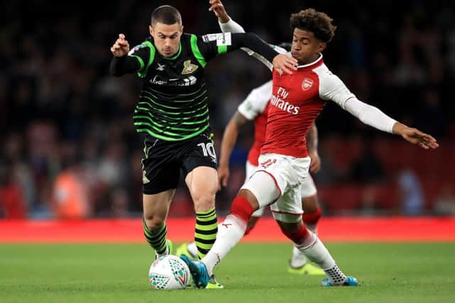 Doncaster Rovers' Tommy Rowe (left) and Arsenal's Reiss Nelson (right) battle for the ball during the Carabao Cup (Picture: PA)
