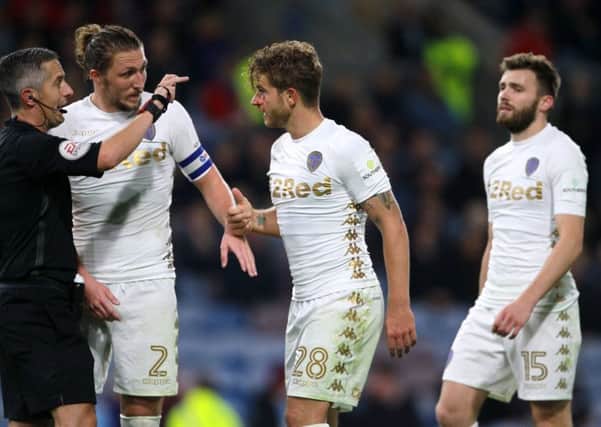 IN THE WARS: Leeds United's Gaetano Berardi (centre) speaks with referee Darren Bond about a cut on his eye at Turf Moor on Tuesday. Picture: Richard Sellers/PA