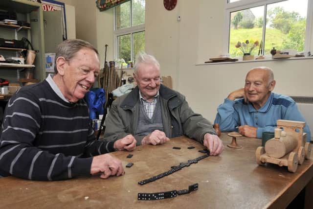 Bob Hodge, Dennis Metcalfe and Malcolm Pickett enjoy a game of dominoes.