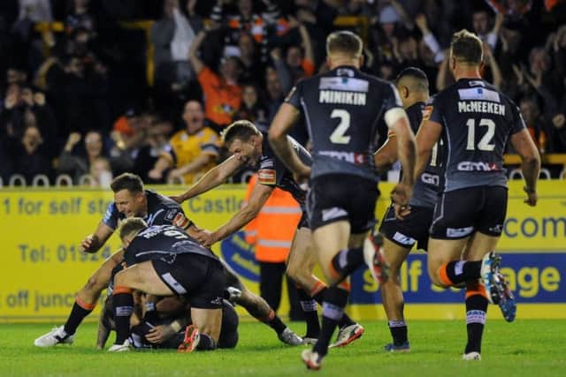 Castleford players jump on Luke Gale after he scored the winning driop goal.
 (Picture: Jonathan Gawthorpe)