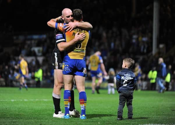 Gareth Ellis and Dannyy McGuire embrace at the end of the match, as McGuire's son Louis looks on.