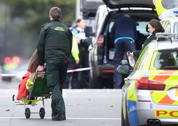 A woman is treated by emergency services at the scene. PIC: PA