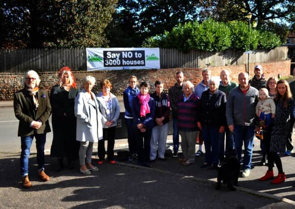 Residents  on the  main street in Green Hammerton , in front of one of the banners protesting  against the 3,000 new homes.
