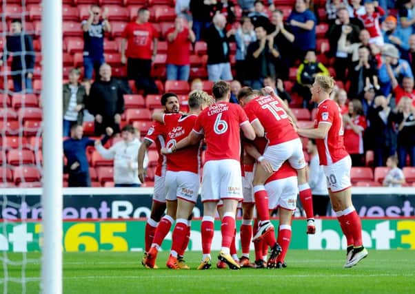Tom Bradshaw, of Barnsley is modded by team mates after scoring his team's first goal.