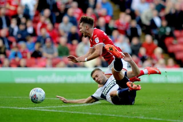 Tom Bradshaw, of Barnsley, is tackled by Ben Gibson, of Middlesbrough (Pictures: James Hardisty)