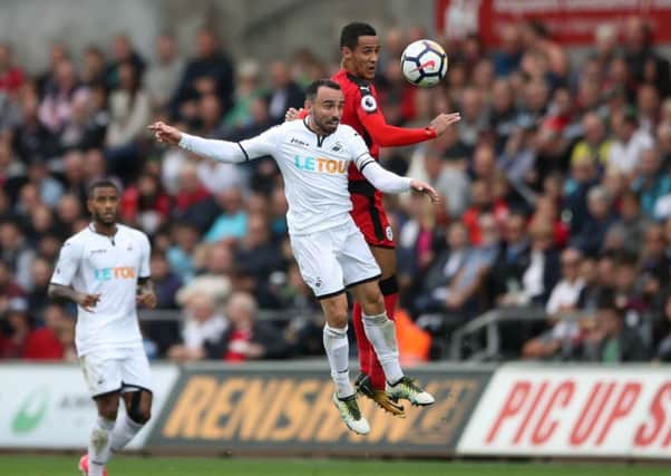Huddersfield Town's Tom Ince (right) and Swansea City's Leon Britton battle for the ball.