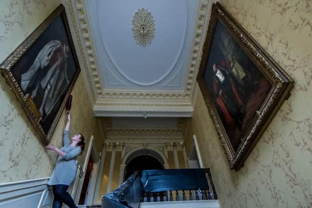 Sarah White, dusting a portrait, at York's Mansion House, ahead of its reopening in December