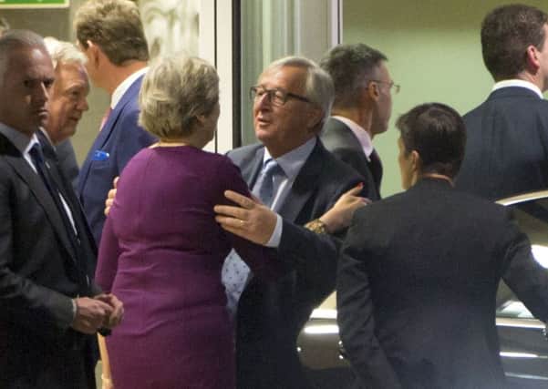 European Commission President Jean-Claude Juncker, centre right, embraces British Prime Minister Theresa May, centre left, after a meeting at EU headquarters in Brussels on Monday.