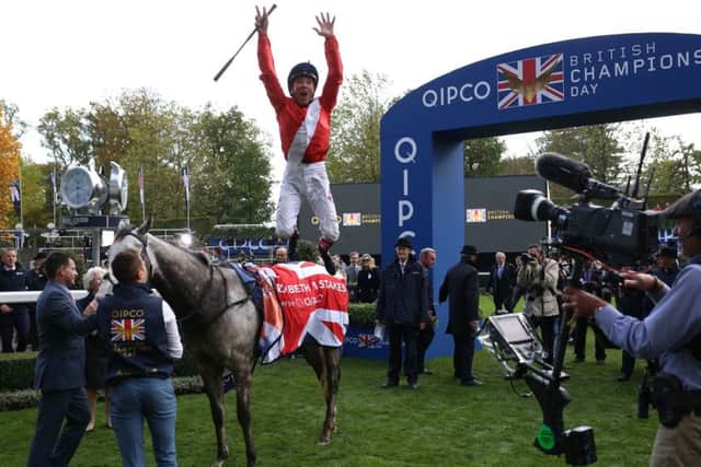 Frankie Dettori does his famous flying dismount from Persuasive after the race.
