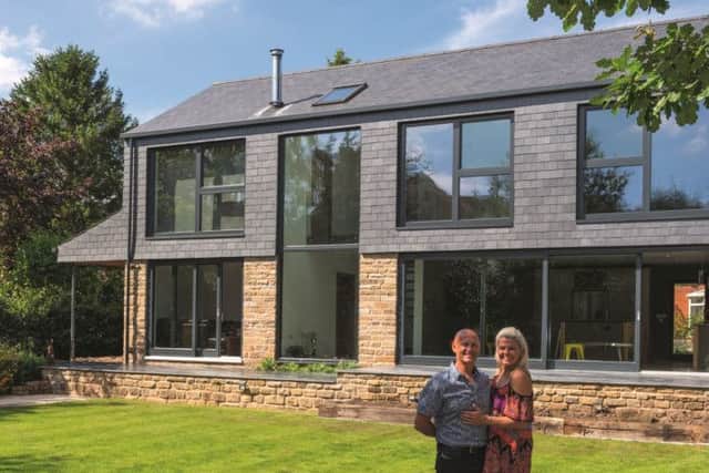 David and Elizabeth Rodgers with their self-build, which is clad in slate and stone.