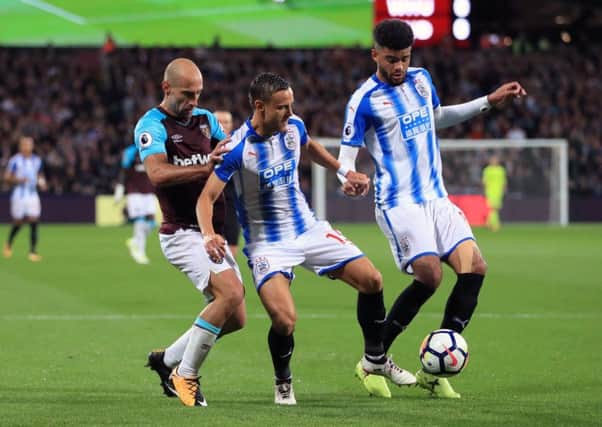Huddersfield Town's Chris Lowe, left, battles for the ball in the defeat at West Ham earlier this season. Picture: John Walton/PA