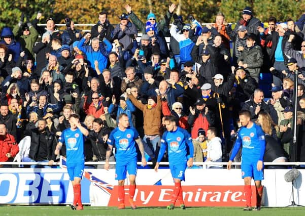 Shaw Lane's players show their disappointment as Mansfield Town fans celebrate their side's second goal of the game at Sheerian Park. Picture: Tim Goode/PA